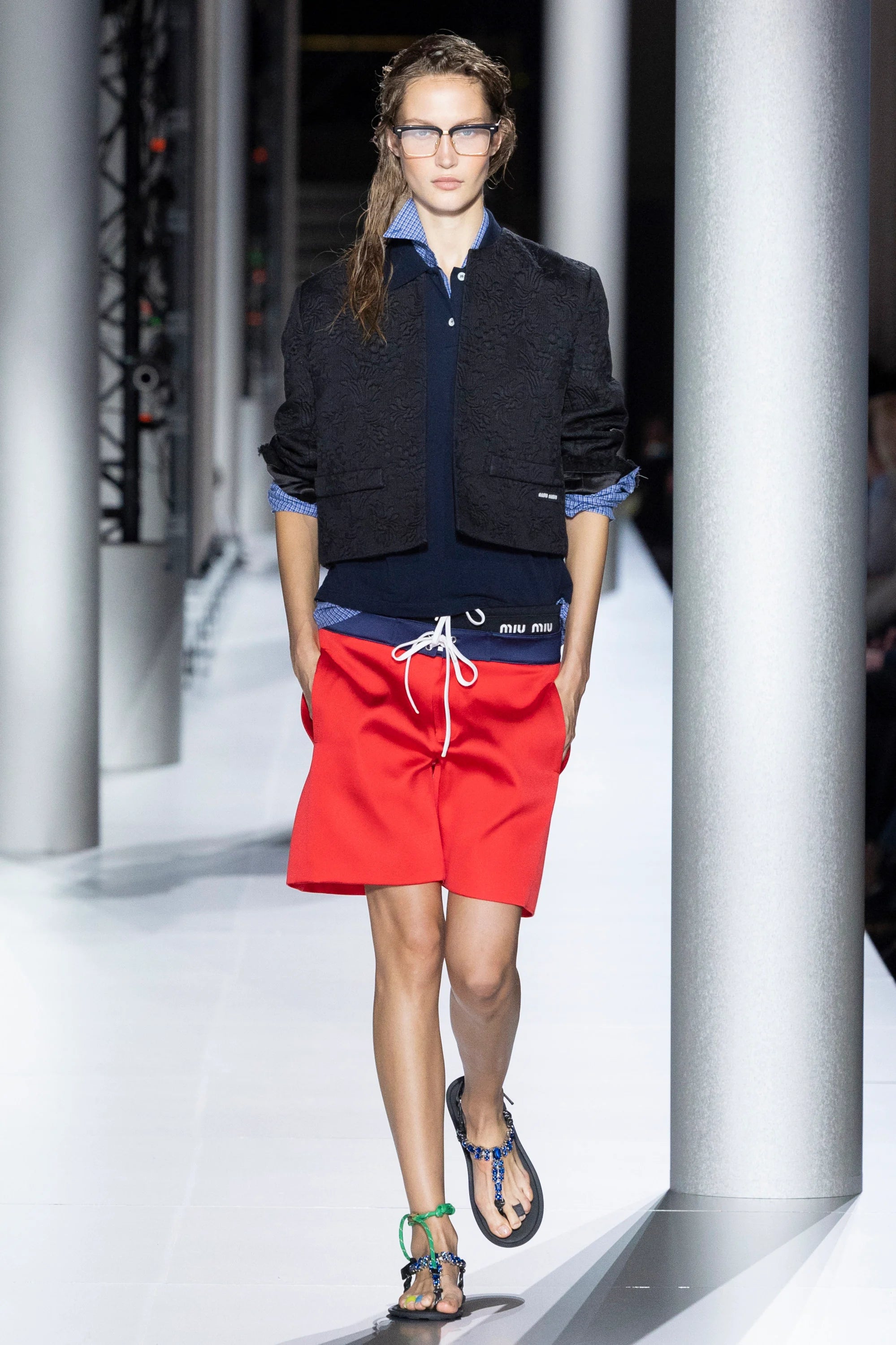 Miu-Miu SS24 collection model wearing flipflops, red shorts and layered top
